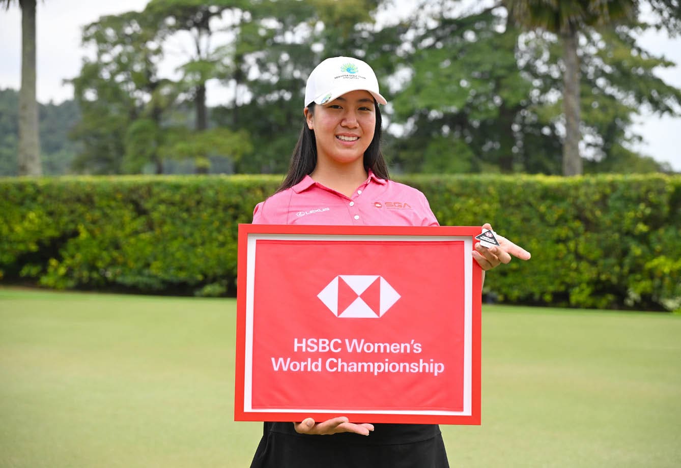 A woman in a pink shirt holds a red sign with the words “HSBC Women's World Championship" on it. AI generated content