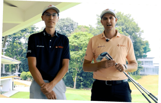 Two men standing on a golf course. Description generated by AI