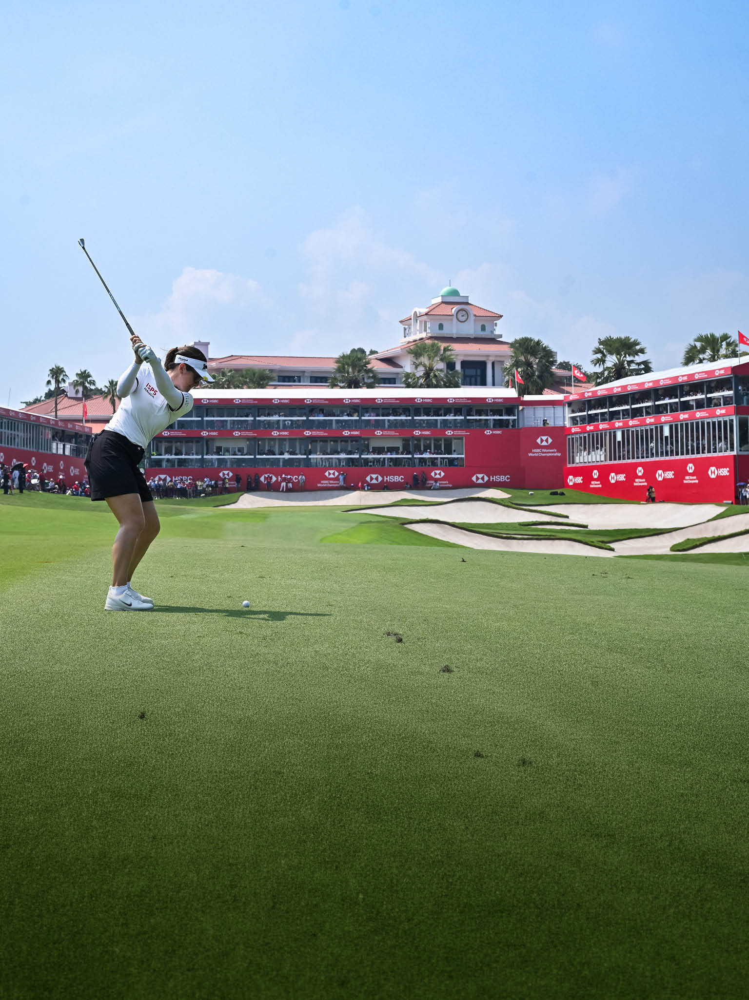 A woman is swinging a golf club on a green course. AI generated content